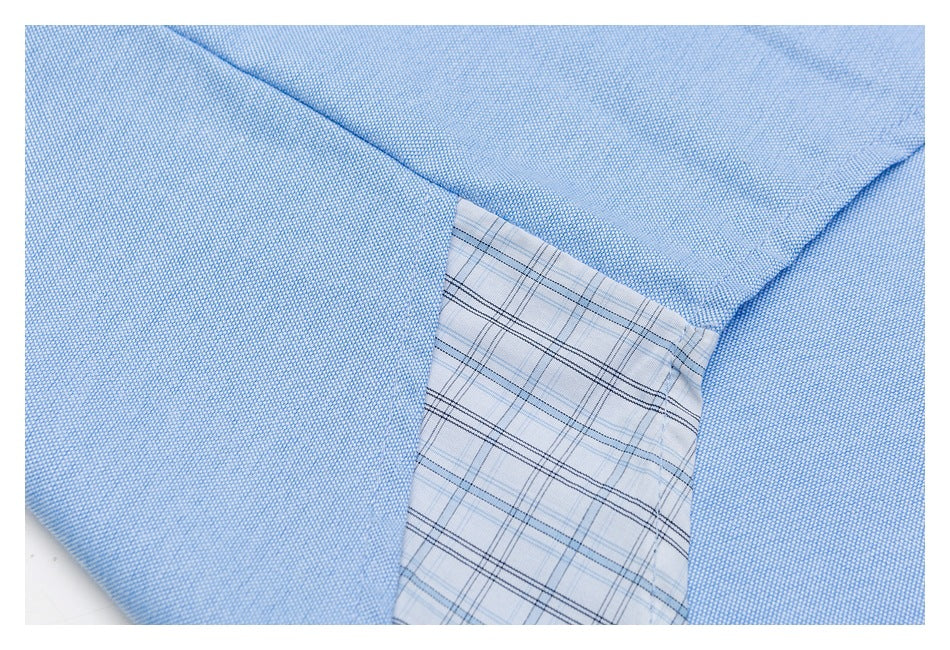 Close-up showing pale blue shirt fabric beside a light plaid inner panel.
