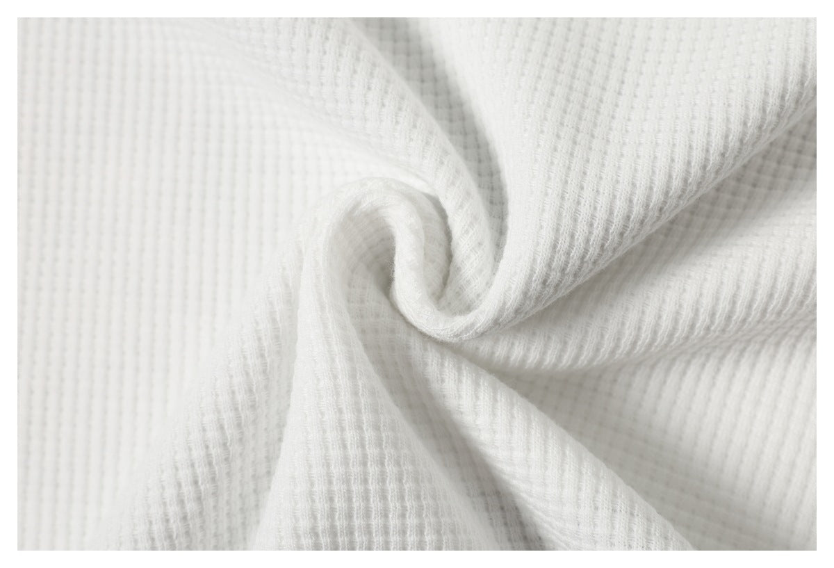 White ribbed fabric gathered into a spiral to show its texture and drape.