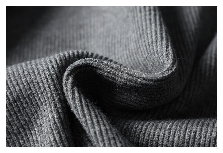 Close-up of charcoal gray rib-knit fabric draped in folds, highlighting its textured weave.