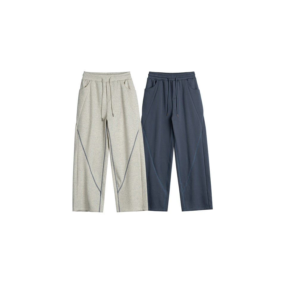 Front view of two wide-leg drawstring pants, one light gray heather and one dark blue-gray, with angled seam details.