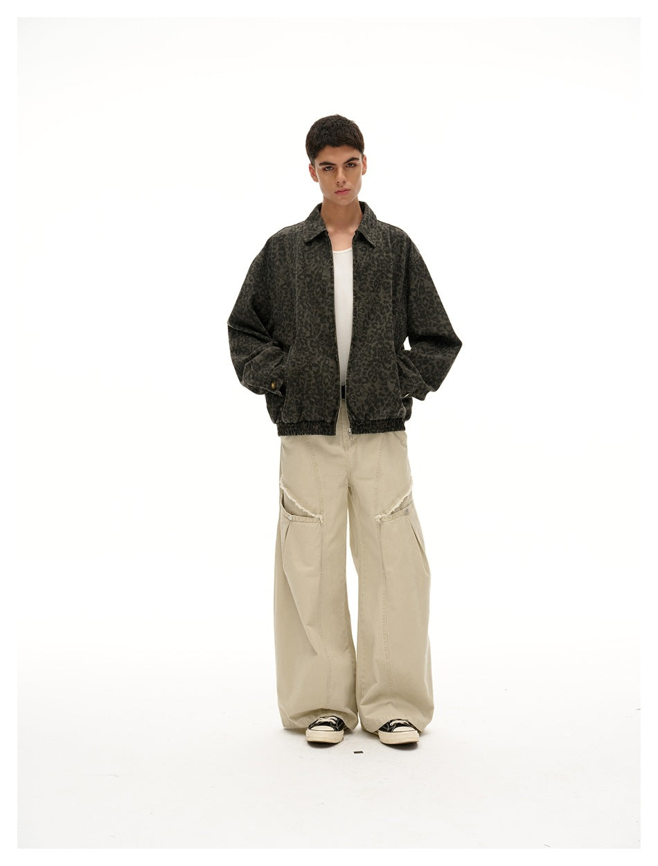 Full-length front view of a model wearing a dark olive leopard-print jacket over a white top and beige trousers.