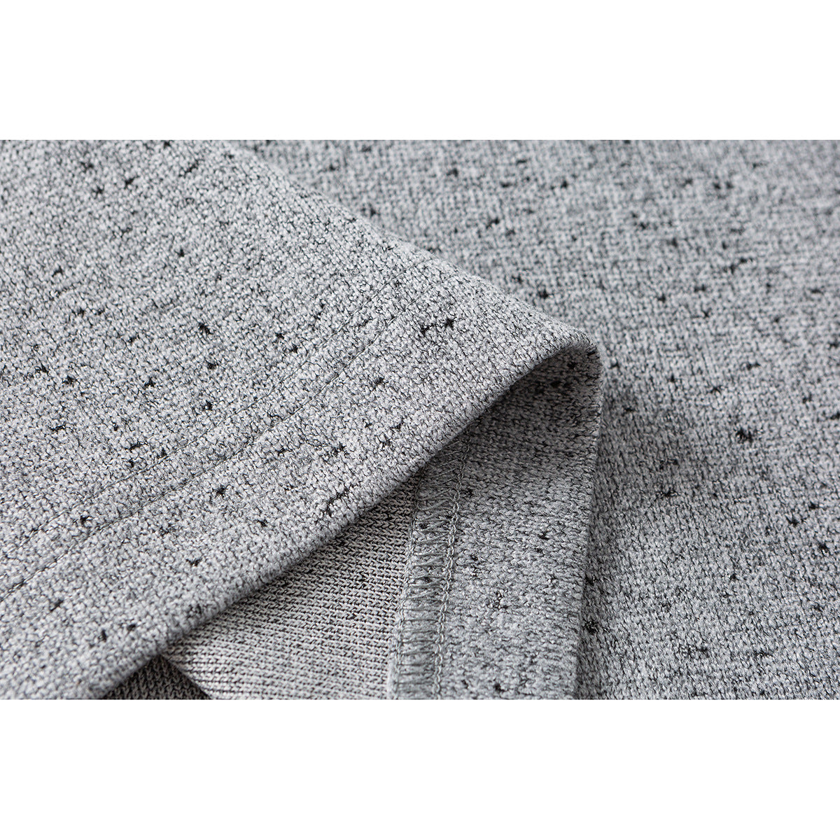 Close-up of speckled gray fabric folded back to show the inside knit and a stitched seam.