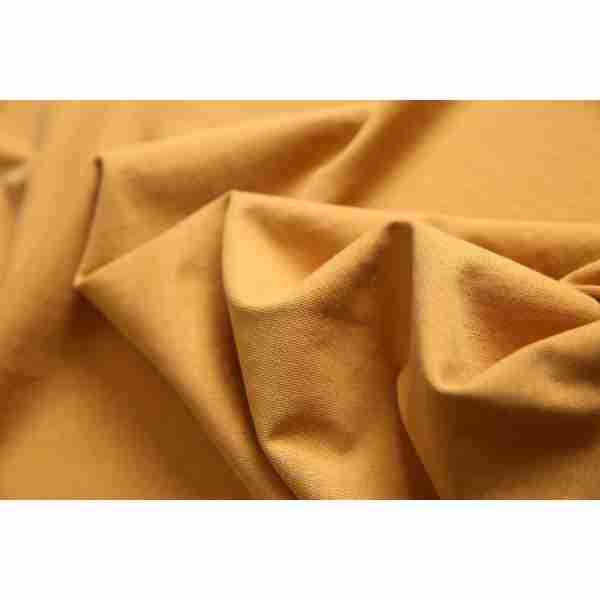 Close-up of mustard-gold fabric gathered into soft folds.