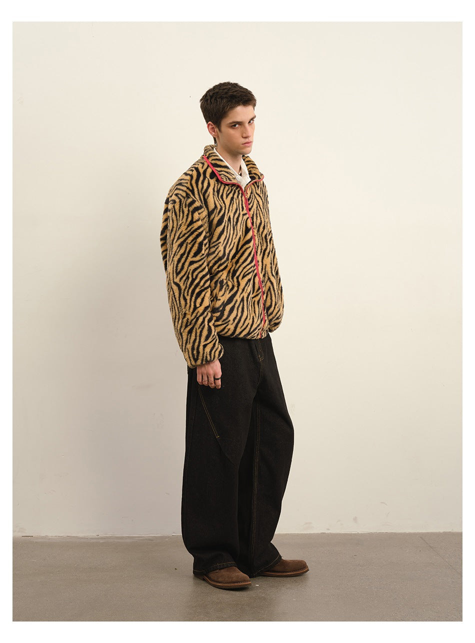 Model in black wide-leg jeans with a tiger-stripe zip jacket, three-quarter side view against a plain wall