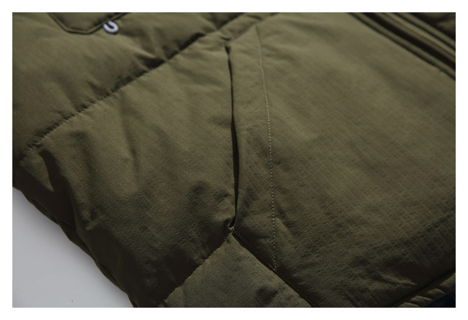 Close-up of the stitched paneling and seams on an olive green jacket.