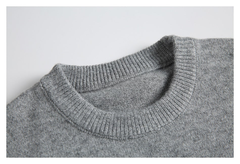 Close-up of a gray knit sweater's ribbed crew neckline.