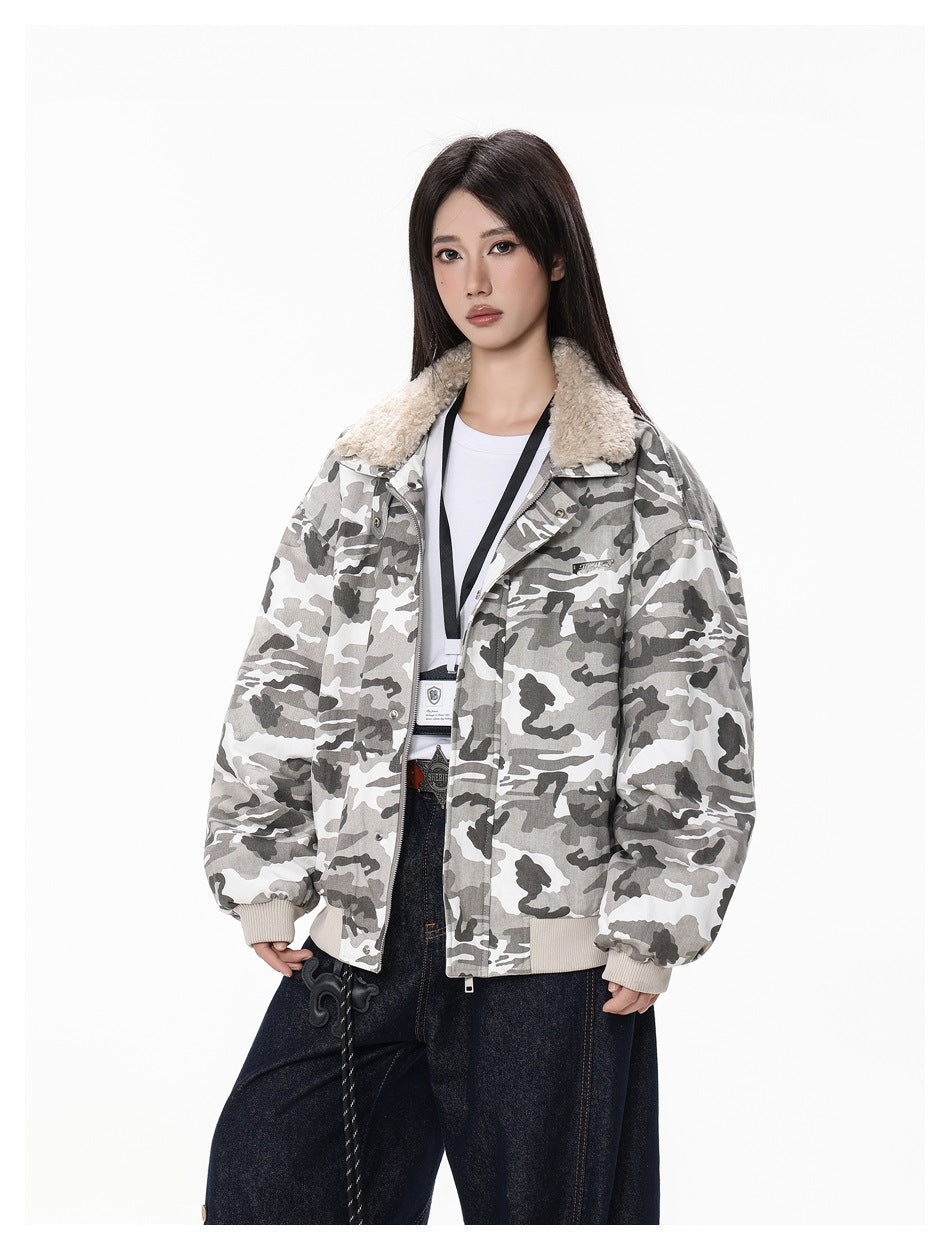 Model wearing an open gray camouflage jacket with fleece-like collar over a white tee, lanyard and dark wide-leg jeans