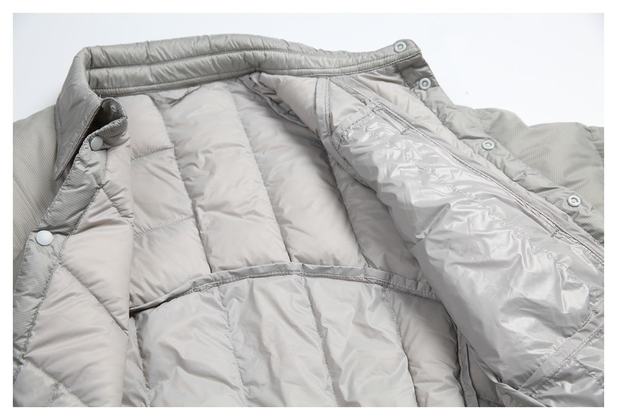 The light gray quilted jacket is opened to show its shiny lining, snap-button placket, and interior construction.