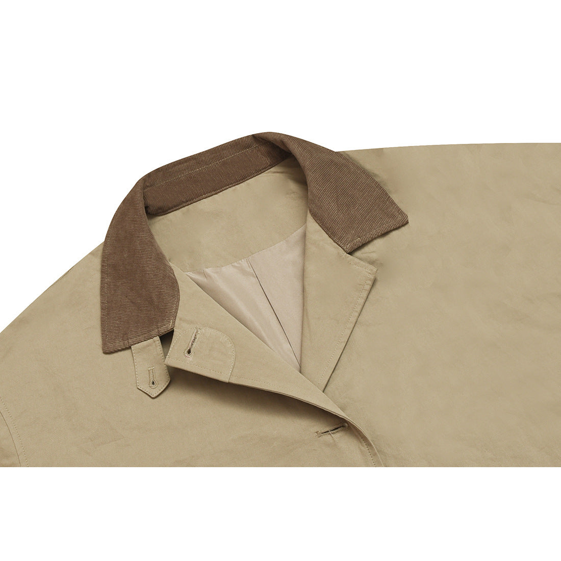 Close-up of a beige coat's wide brown corduroy collar, lapels, button tabs, and pale lining.
