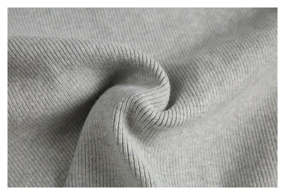 Close-up of light gray ribbed knit fabric gathered into a soft fold.