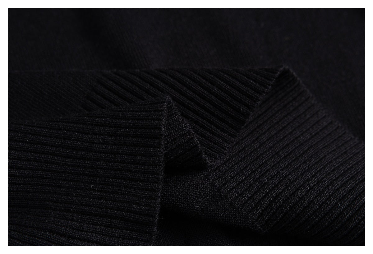 Close-up of folded black rib-knit garment edges, showing the ribbed texture.