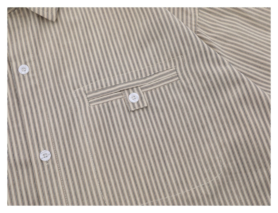 Close-up of the striped shirt's chest pocket, buttoned tab, stitching, and white buttons.