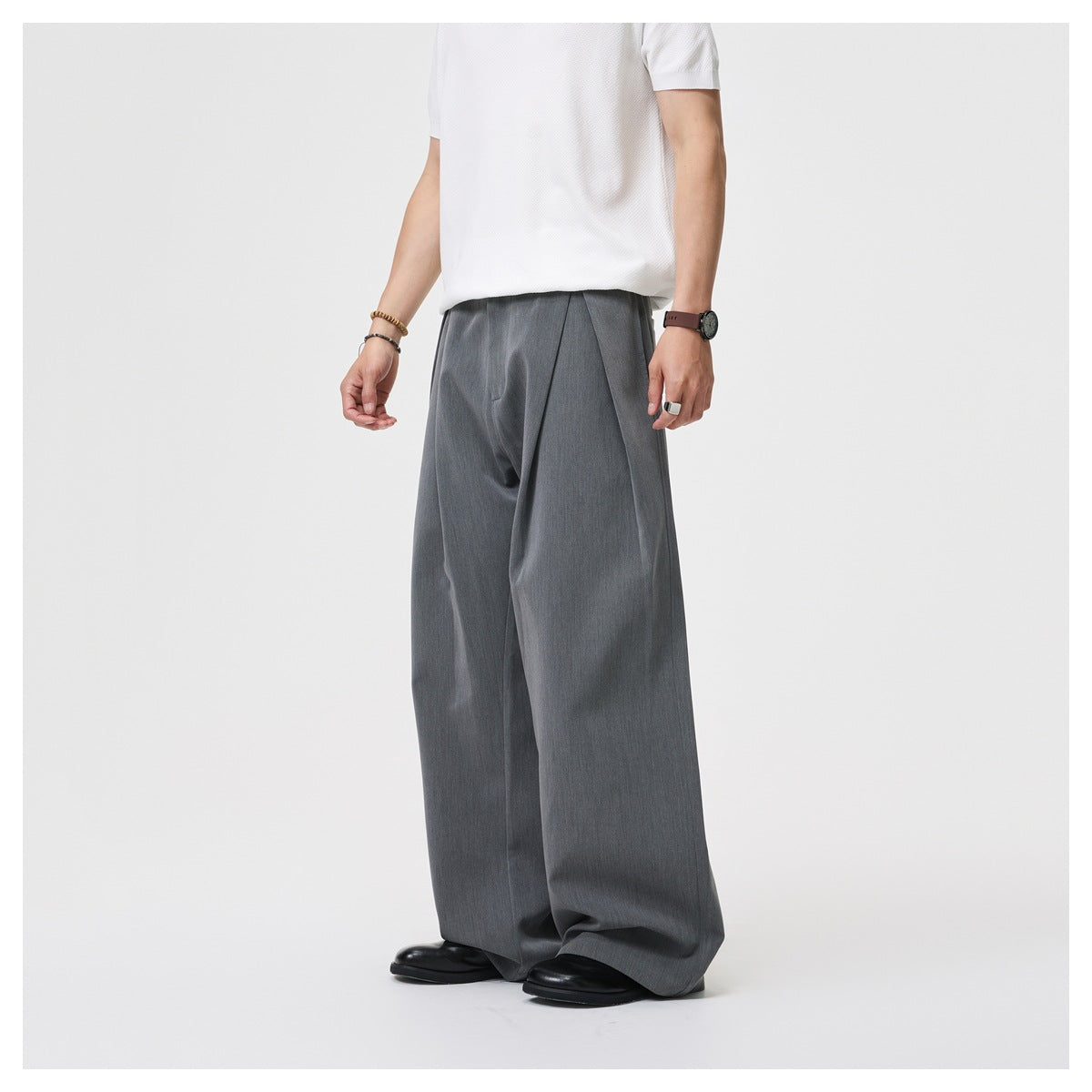 Cropped model wearing charcoal-gray wide-leg trousers with a white shirt, shown from a slight front angle.