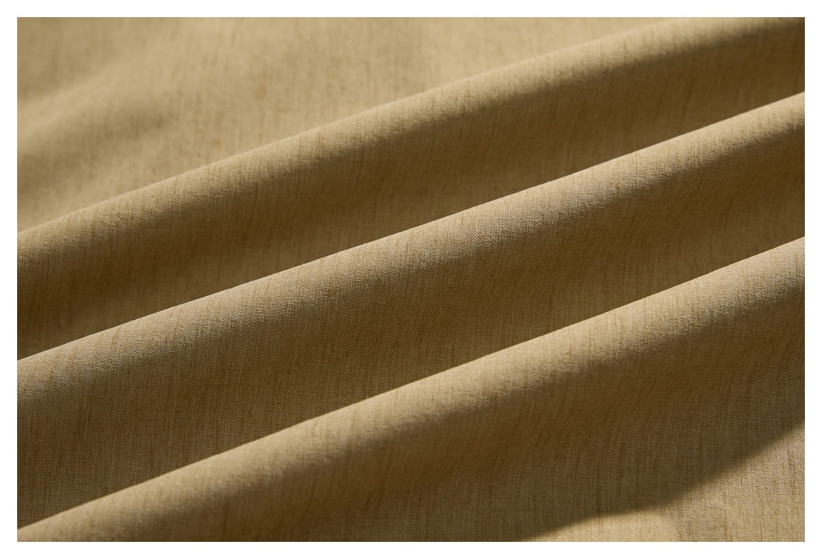 Close-up of tan-brown woven fabric arranged in broad folds.