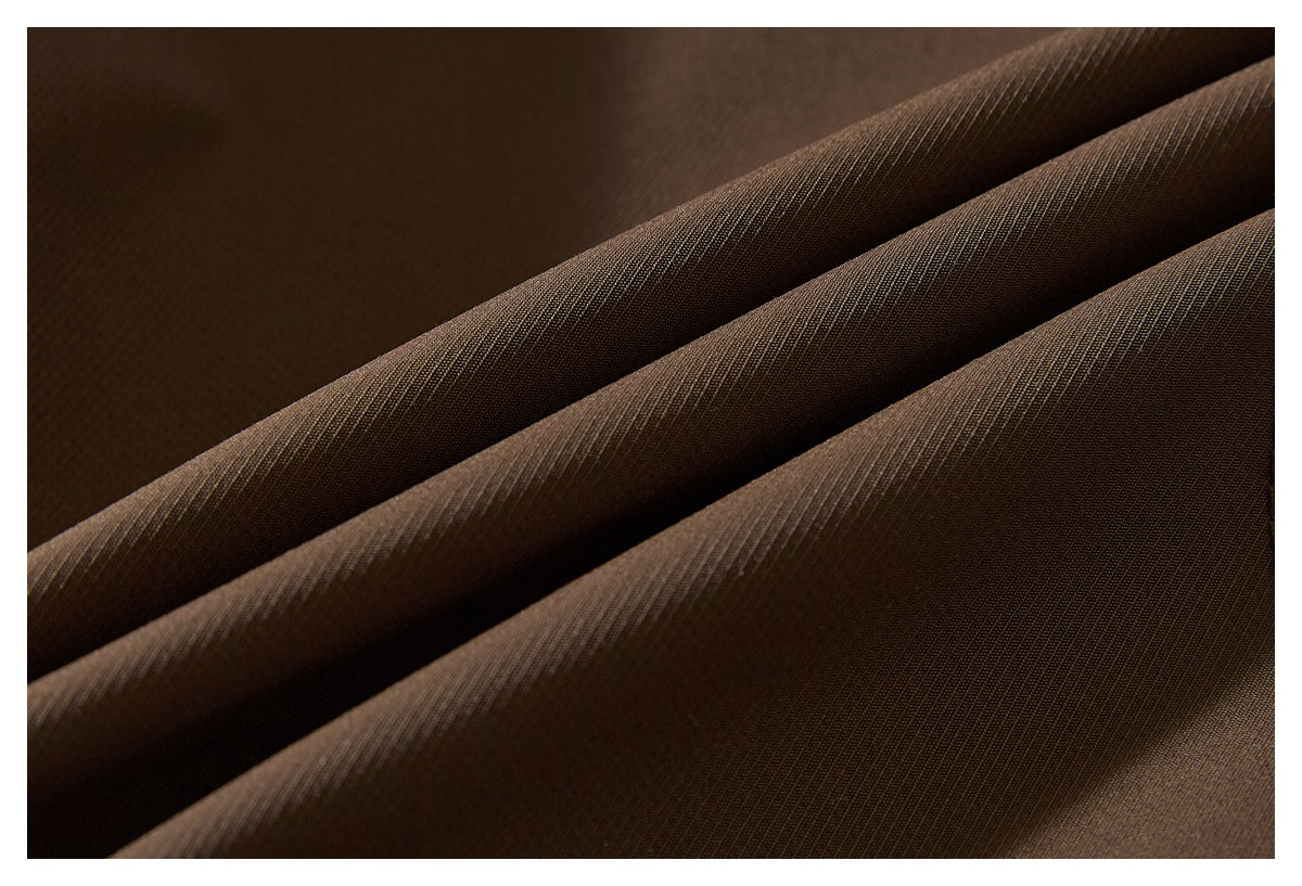 Macro view of brown jacket fabric arranged in soft diagonal folds.