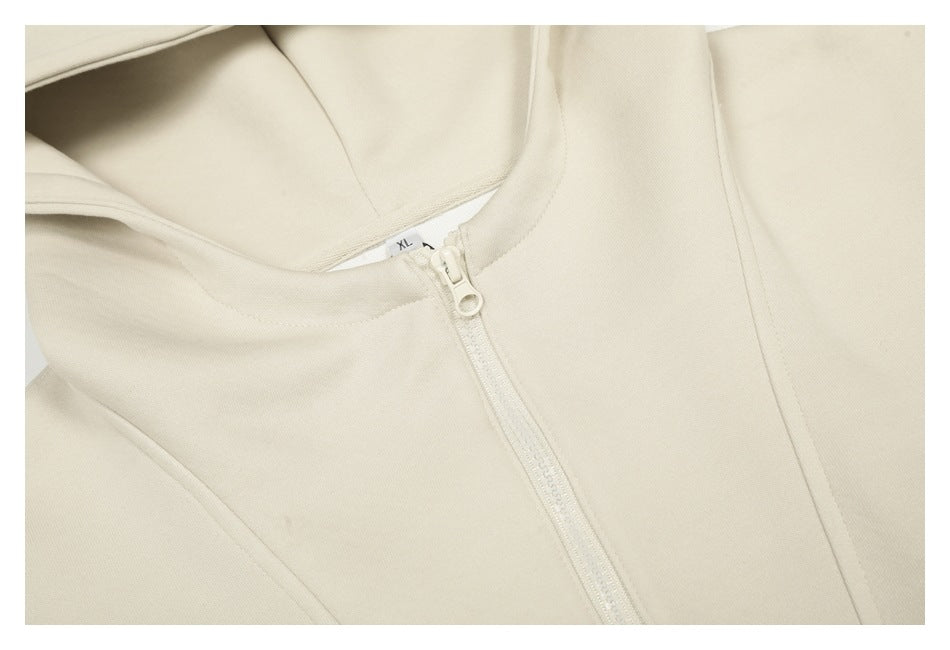 Close-up of the cream hoodie’s front zipper, collar, and hood opening.