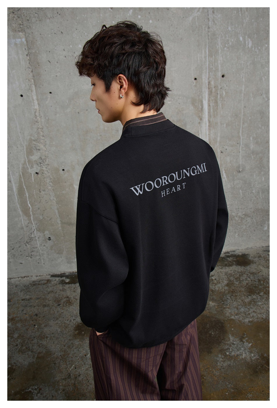 Model wearing a black oversized sweatshirt with gray WOOROONGMI HEART lettering across the back.