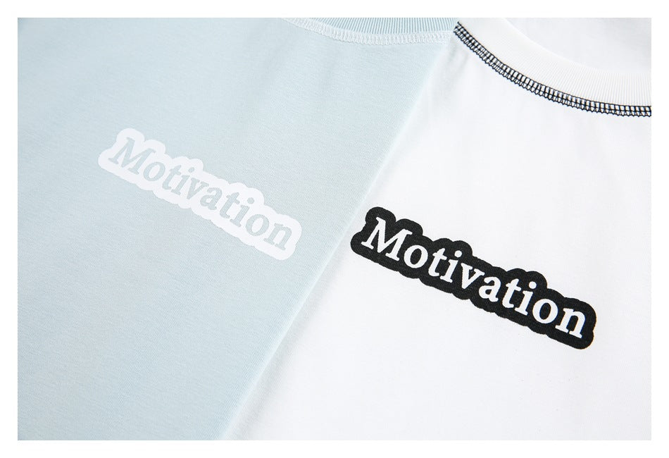 Close-up of pale blue and white T-shirts with contrasting “Motivation” chest prints.
