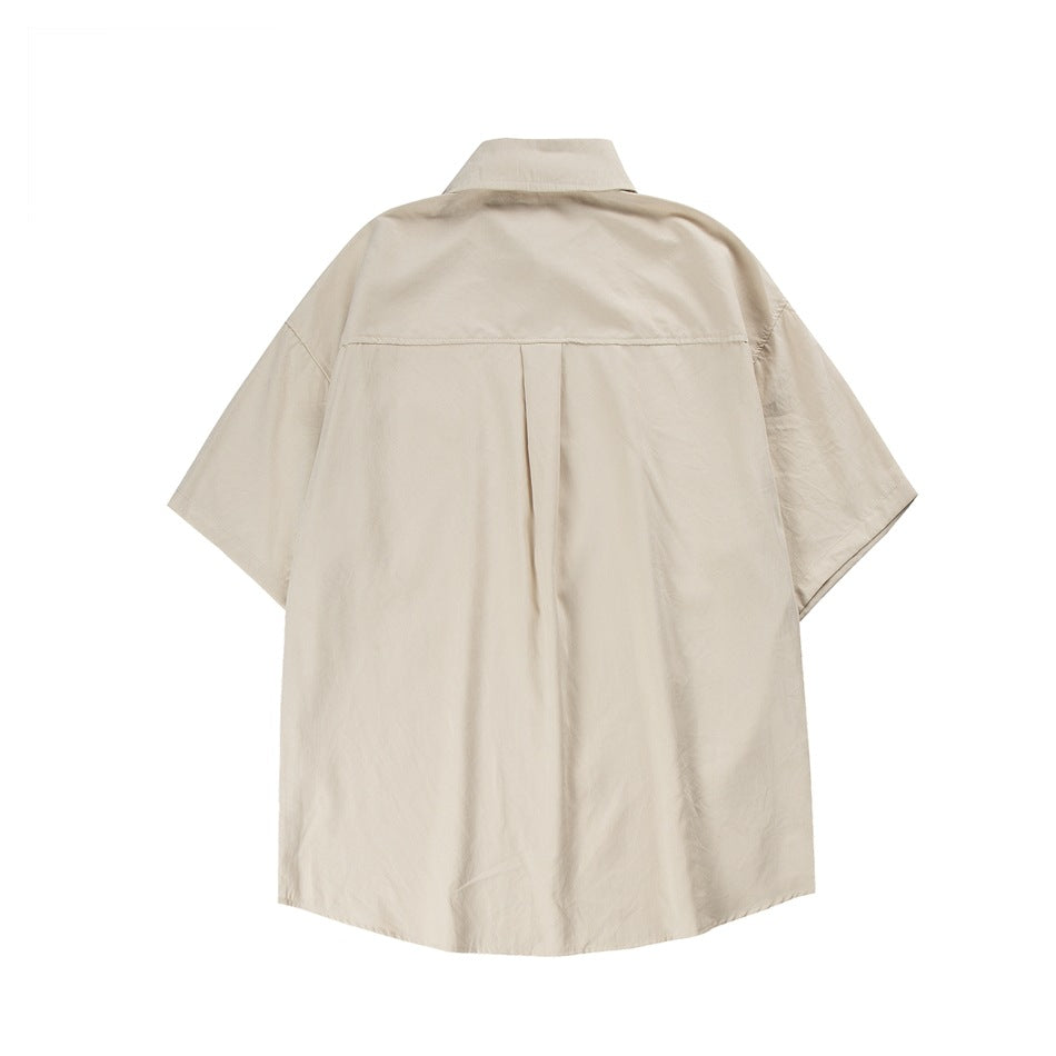 Back view of a beige short-sleeve button-up shirt with a pointed collar and center back pleat.