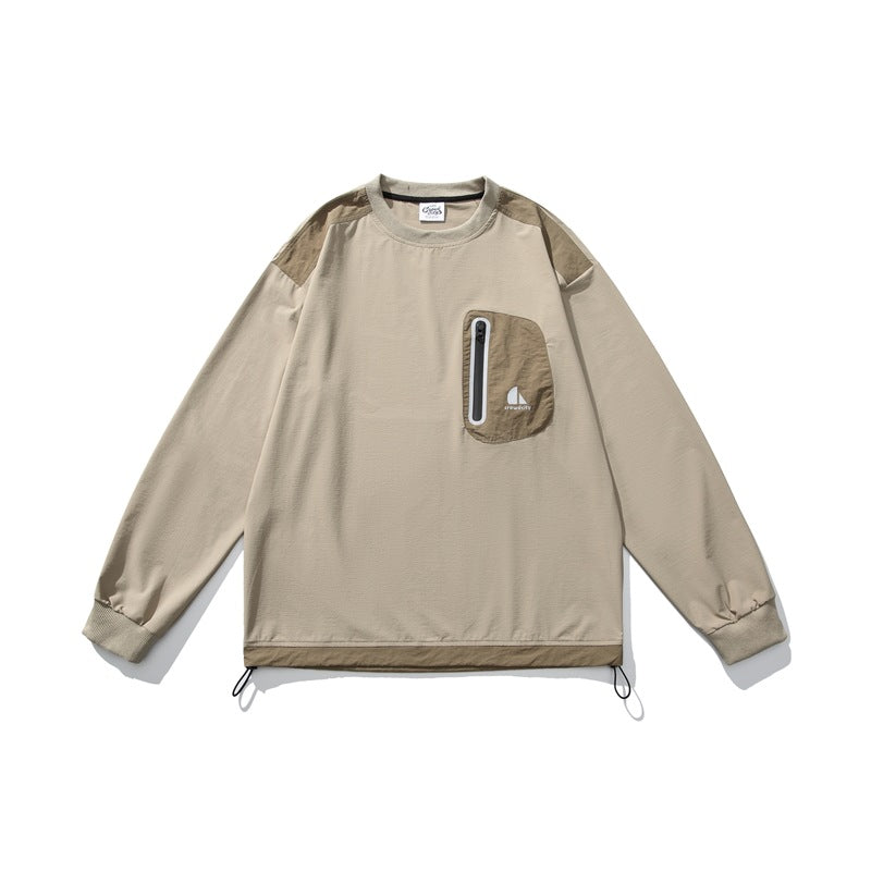 Khaki crewneck pullover with darker tan shoulder panels, zip chest pocket, ribbed cuffs and drawcord hem, flat lay front