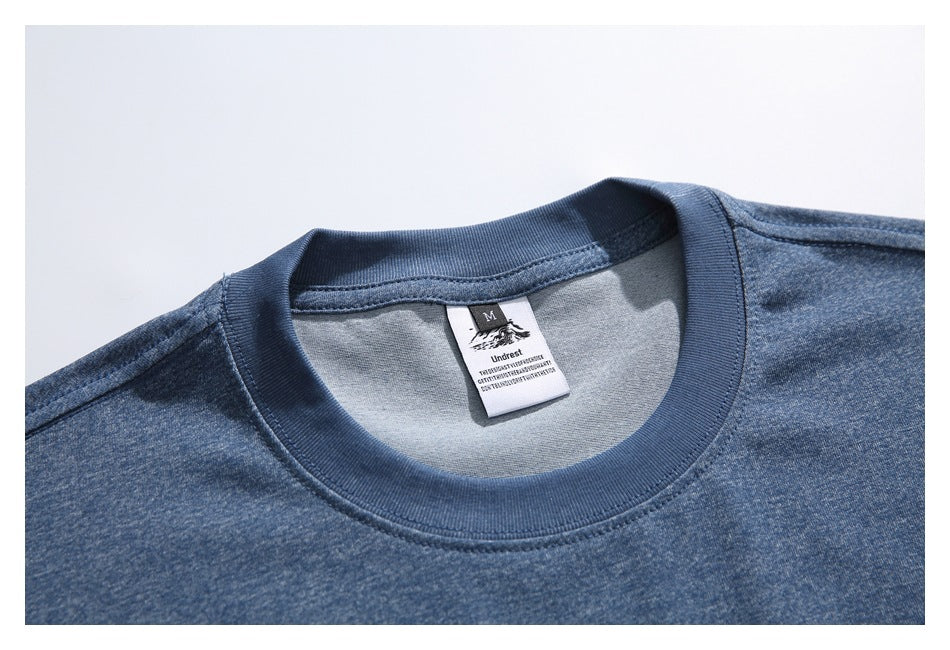 Close-up of the blue T-shirt's ribbed crew neck and attached size and brand label.