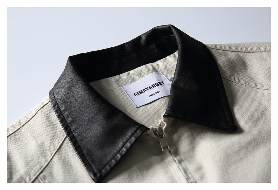 Close-up of an off-white jacket with a black contrast collar, front zipper and sewn neck label.