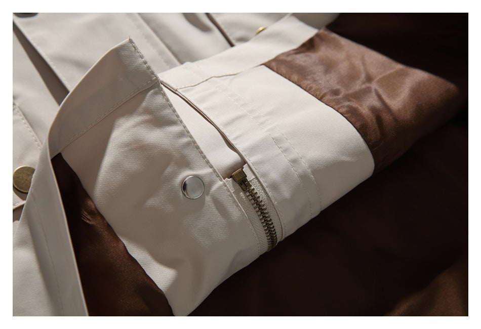 Close-up of a beige jacket's zipper fastening beside its dark brown lining.