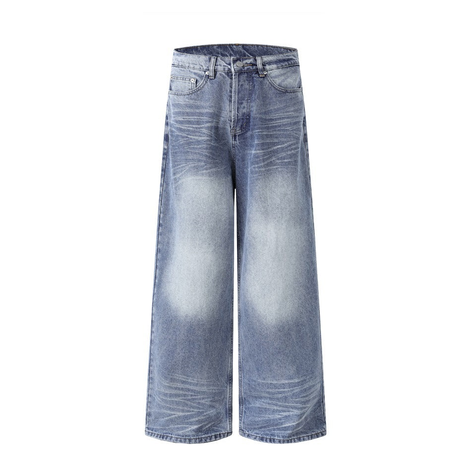 Front of washed blue wide-leg jeans with faded thigh and knee patches and whiskering