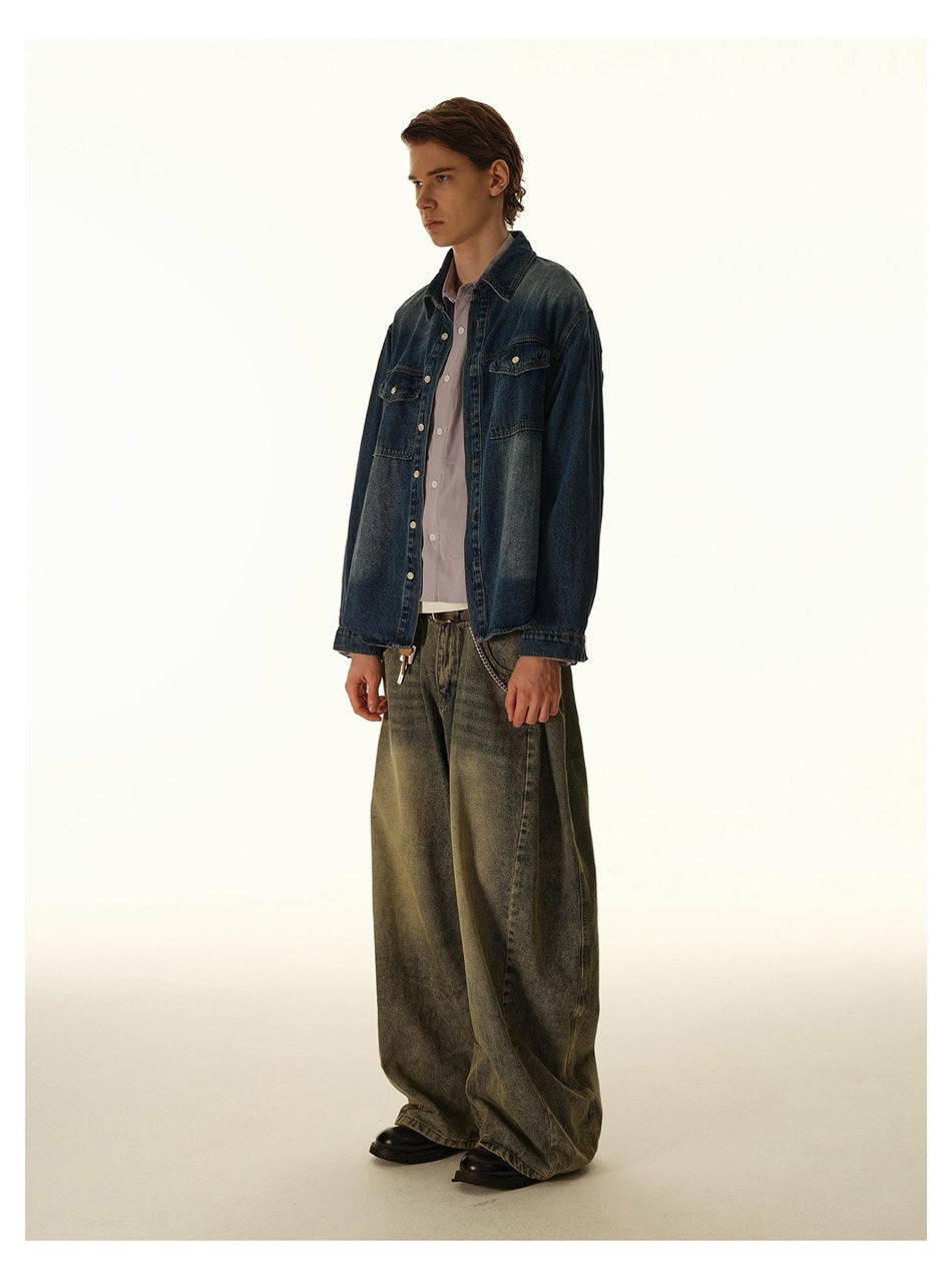 Three-quarter view of a man wearing a dark blue denim overshirt with button-flap chest pockets.