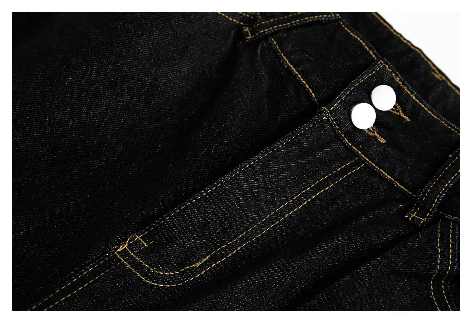 Close-up of the jeans' two-button waistband and front pocket with contrasting gold stitching.