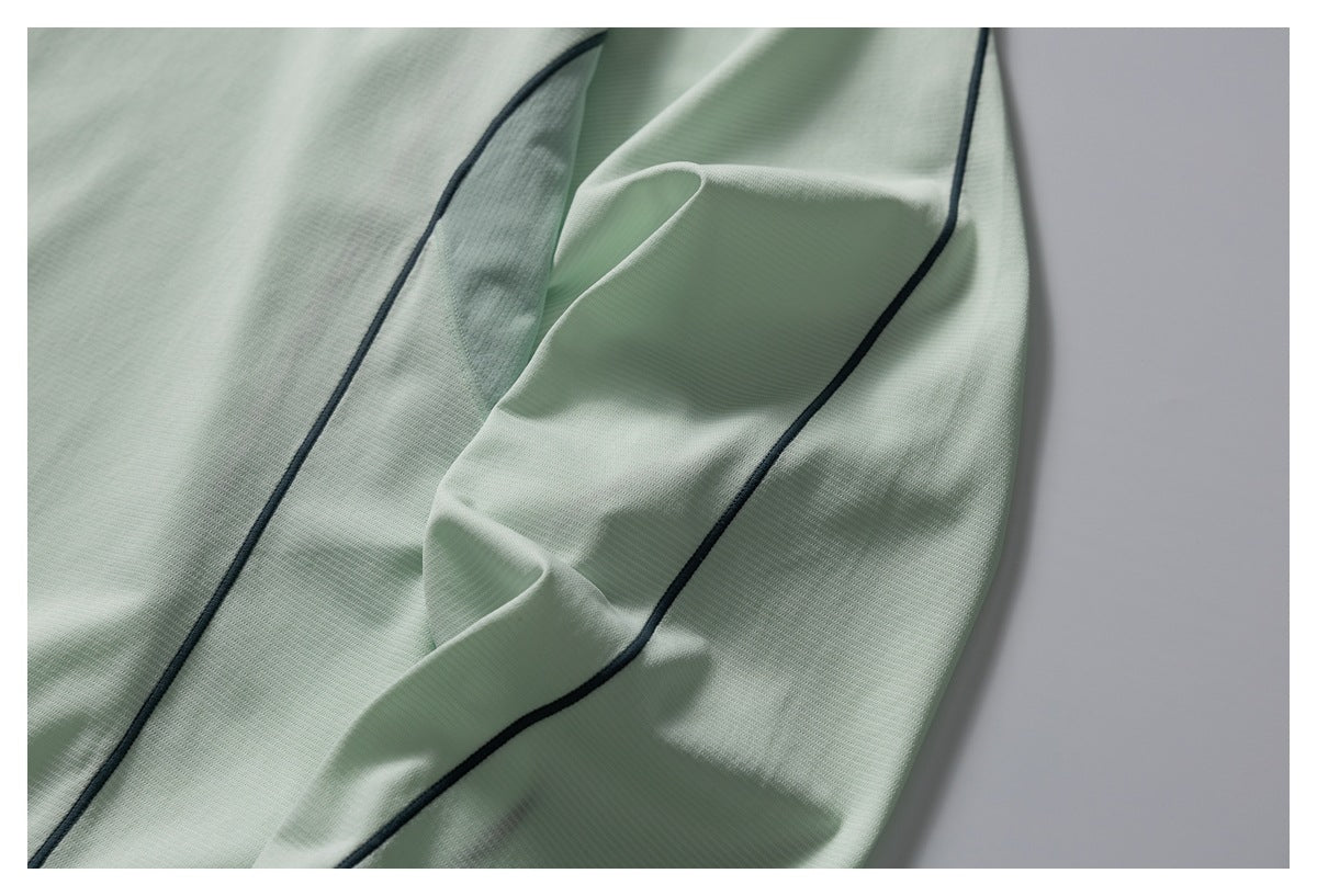 Close-up of dark piping and curved panel stitching on the pale mint shirt.