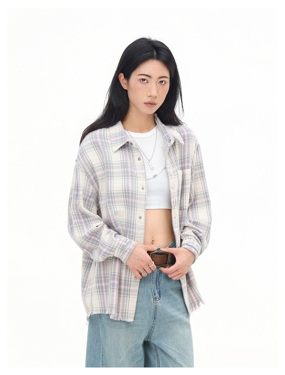 Model wearing an open cream, gray and pale pink plaid shirt over a white crop top.