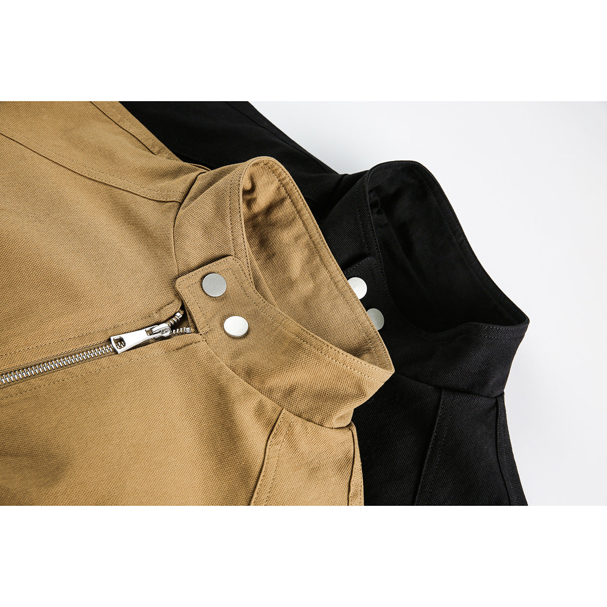 Close-up of tan and black jackets showing stand collars, silver snaps and front zipper details.