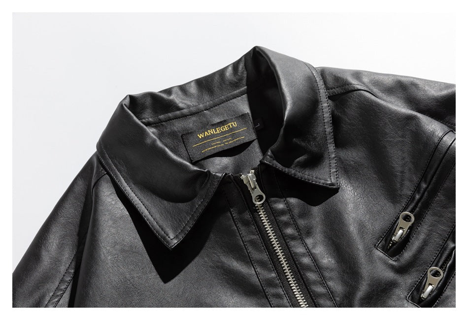 Close-up of a black jacket's wide pointed collar, silver front zipper, and two zip pockets; neck label is visible.