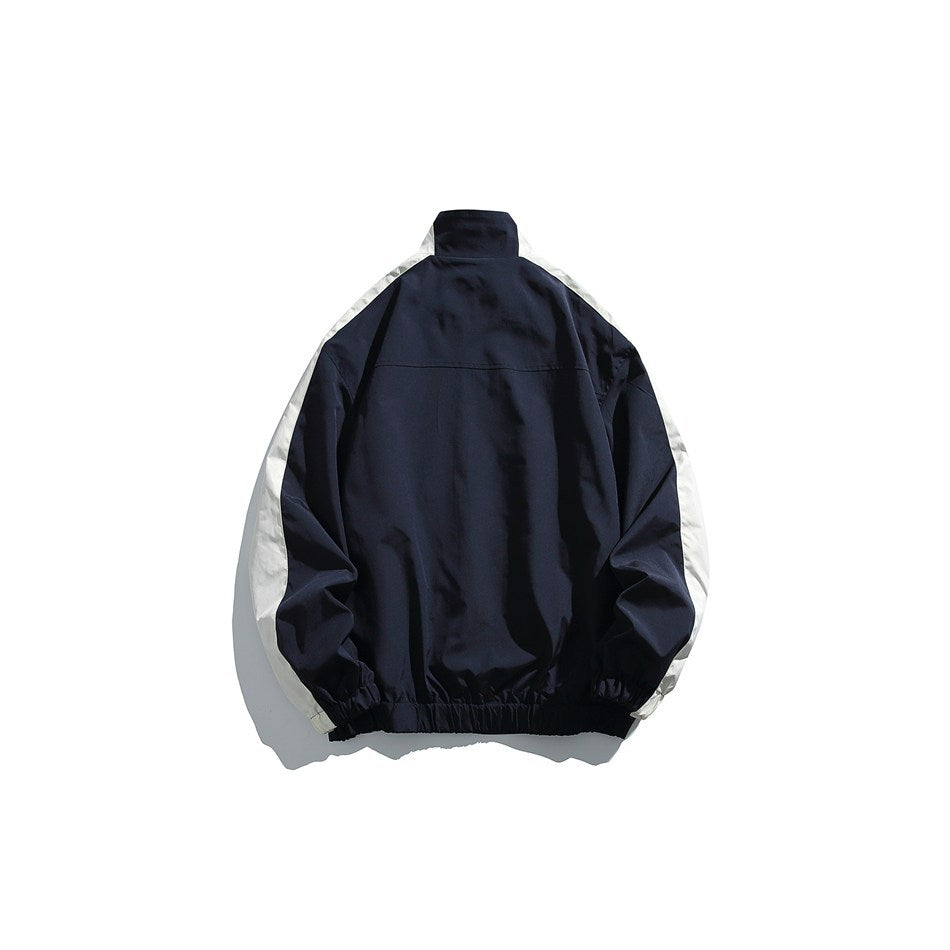 Back view of a navy jacket with white sleeve panels, a high collar, and an elastic hem.