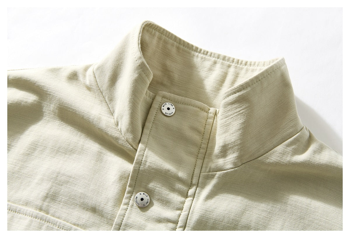 Close-up of a pale beige jacket's stand collar and placket with two round buttons.