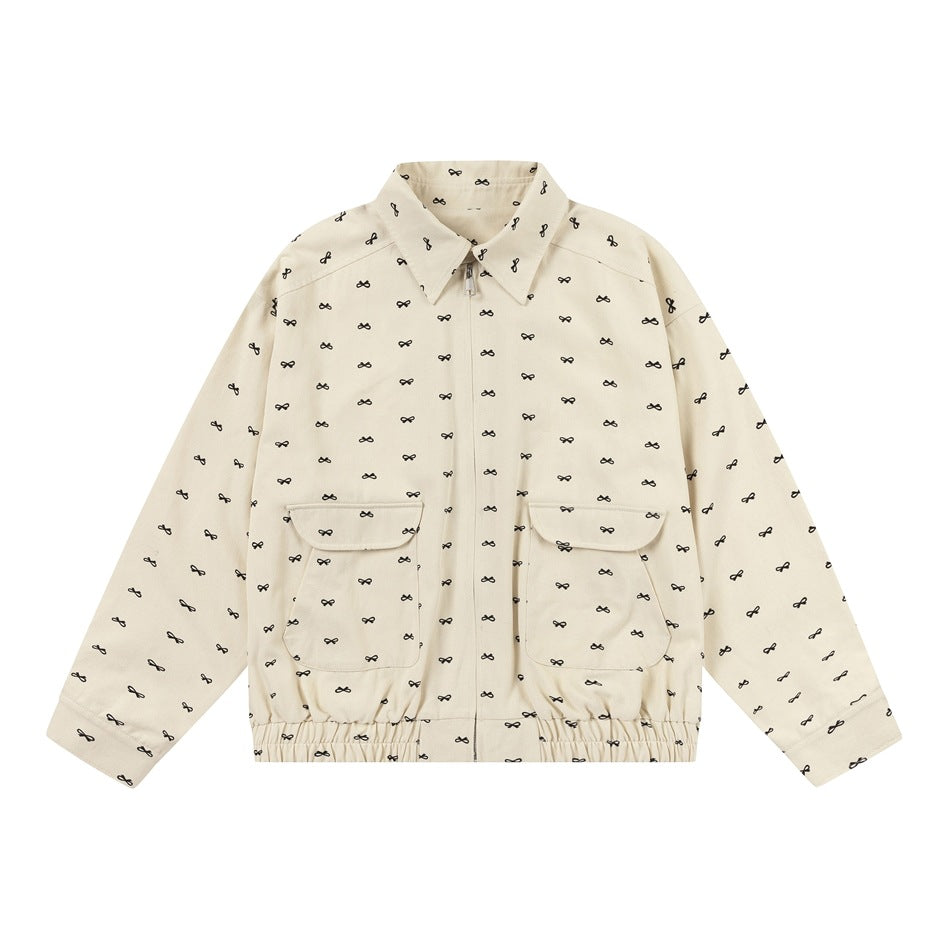 Apricot zip-front jacket with all-over black bow print, flap pockets and elastic hem, flat lay front view