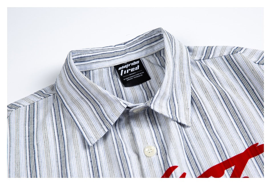 Close-up of the collar and upper chest of a white shirt with narrow blue-gray stripes and partial red print.