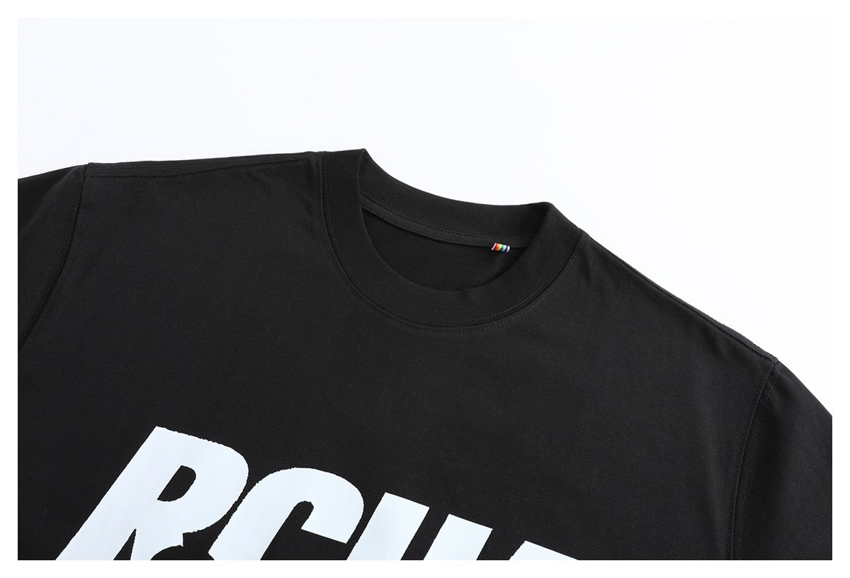 Close-up of a black crew-neck T-shirt with part of a large white chest print and a small multicolor neck tag.