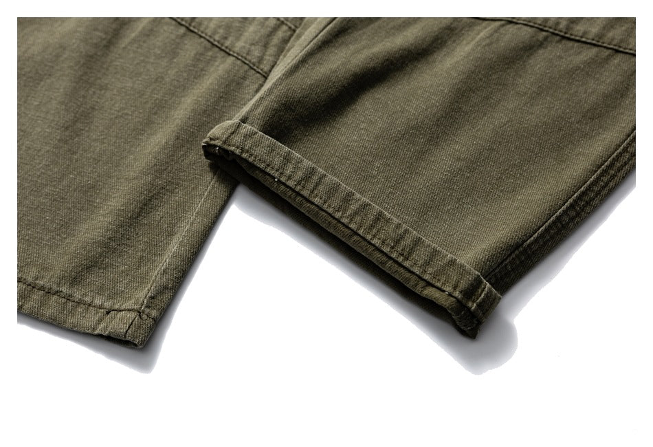 Close-up of olive-brown trouser legs with a turned-up hem and visible stitching.