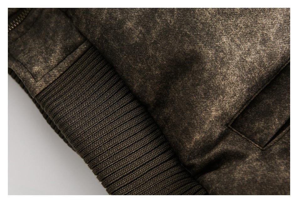 Close-up of a dark brown mottled jacket with a wide rib-knit cuff and a small welt pocket.