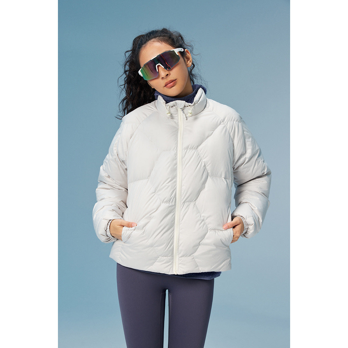 Model wearing a white quilted zip jacket with a high collar and side pockets.