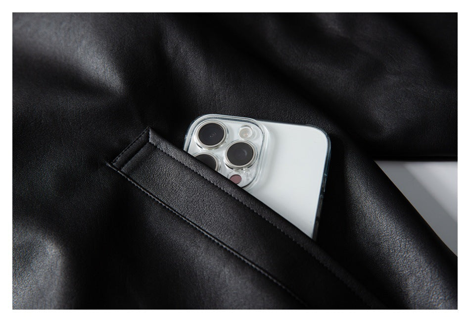 Close-up of a black jacket pocket holding a white smartphone.