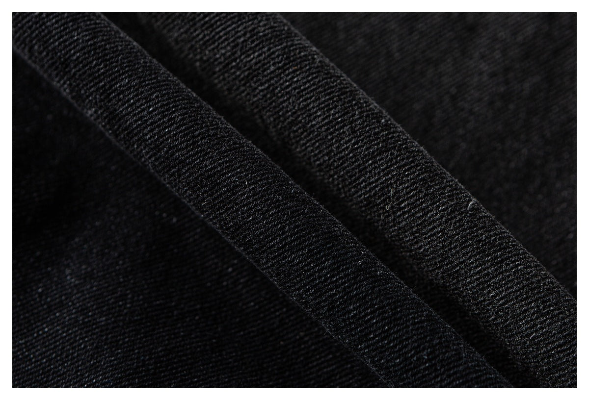 Close-up of black textured fabric with a raised folded seam running diagonally.