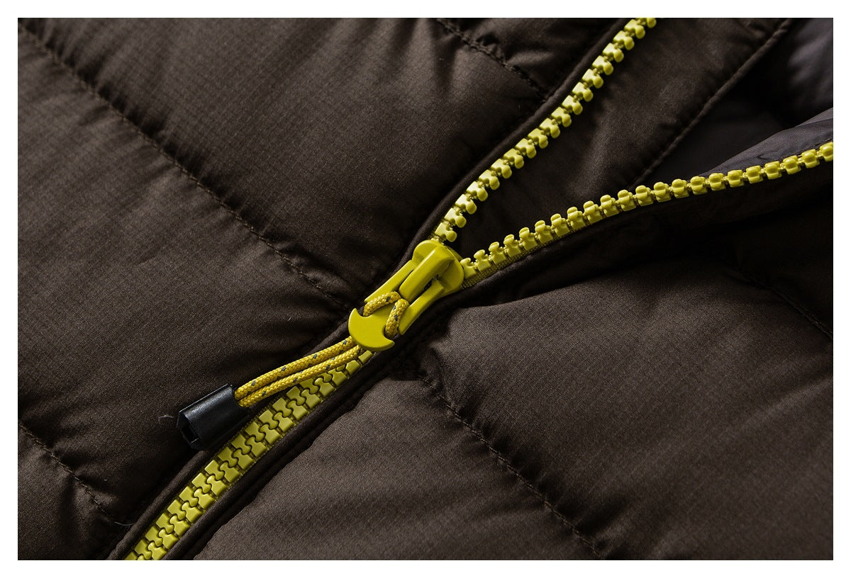 Close-up of a dark brown padded jacket with a bright yellow zipper and corded pull.