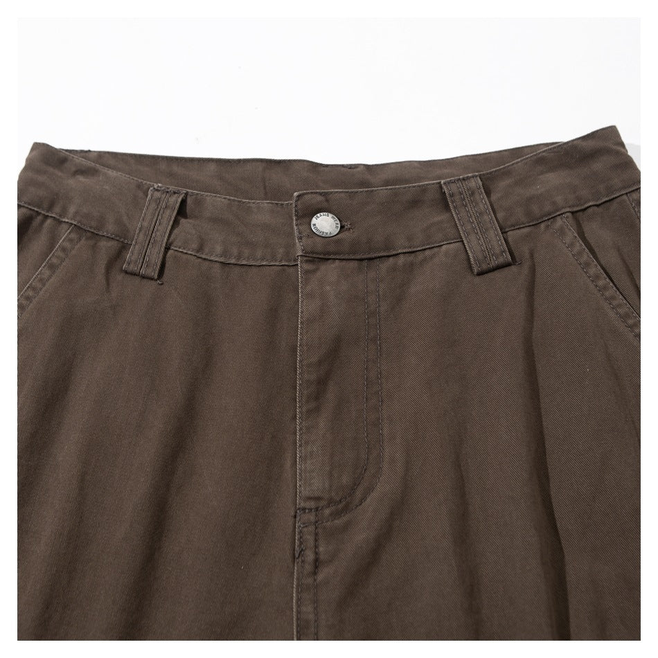 Close-up of the dark brown trousers' waistband, belt loops, button, and fly.