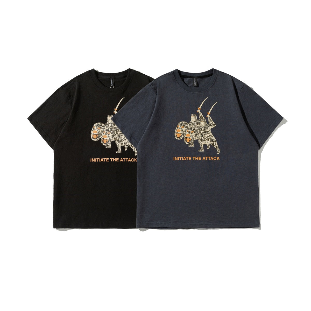 Front view of black and charcoal crew-neck T-shirts with matching cream-and-orange tiger-rider graphics and text.