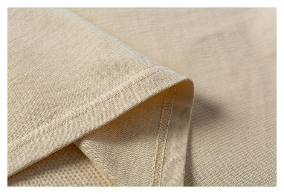 Close-up of a beige T-shirt sleeve hem, showing the stitching and inside seam finish.