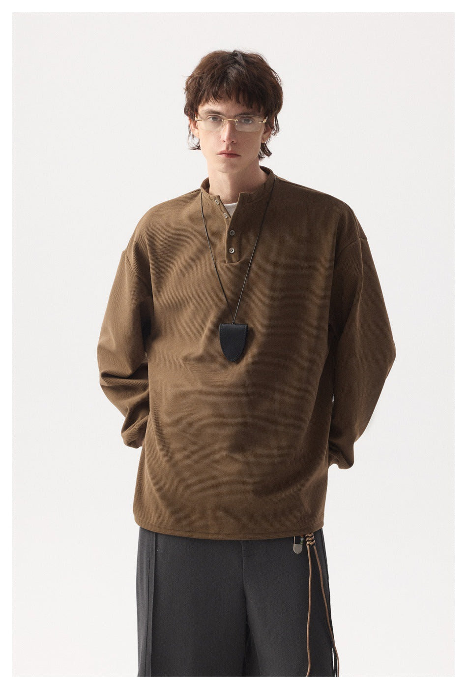 Model wearing a brown long-sleeve henley with a short button placket and relaxed fit.