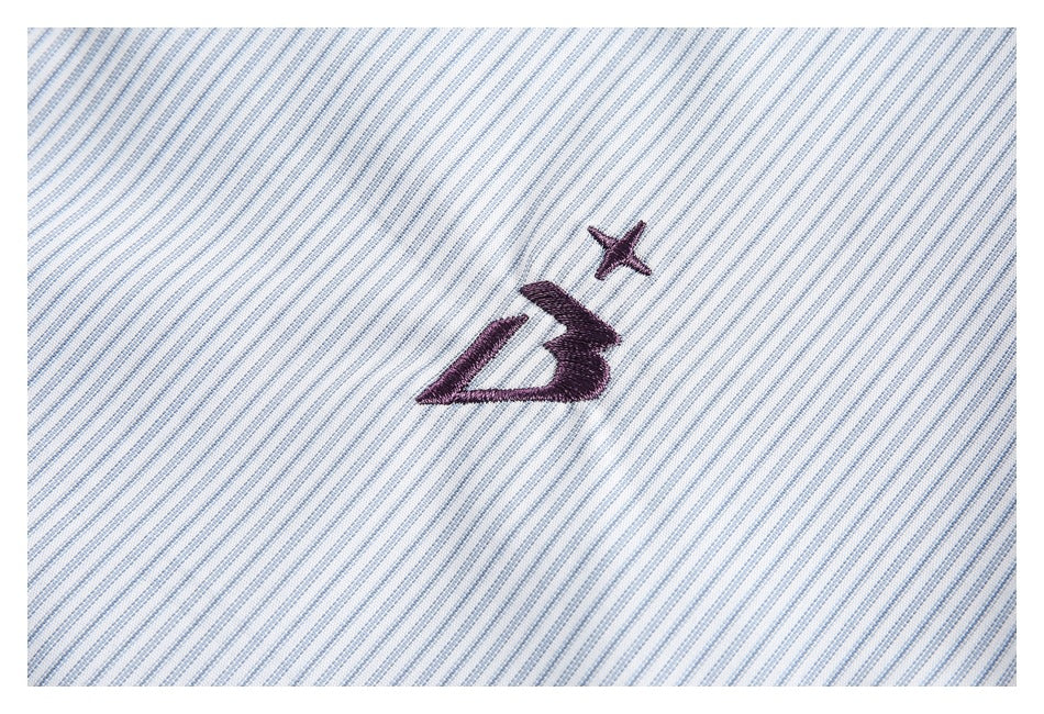 Close-up of a dark embroidered emblem on diagonal light blue and white striped fabric.
